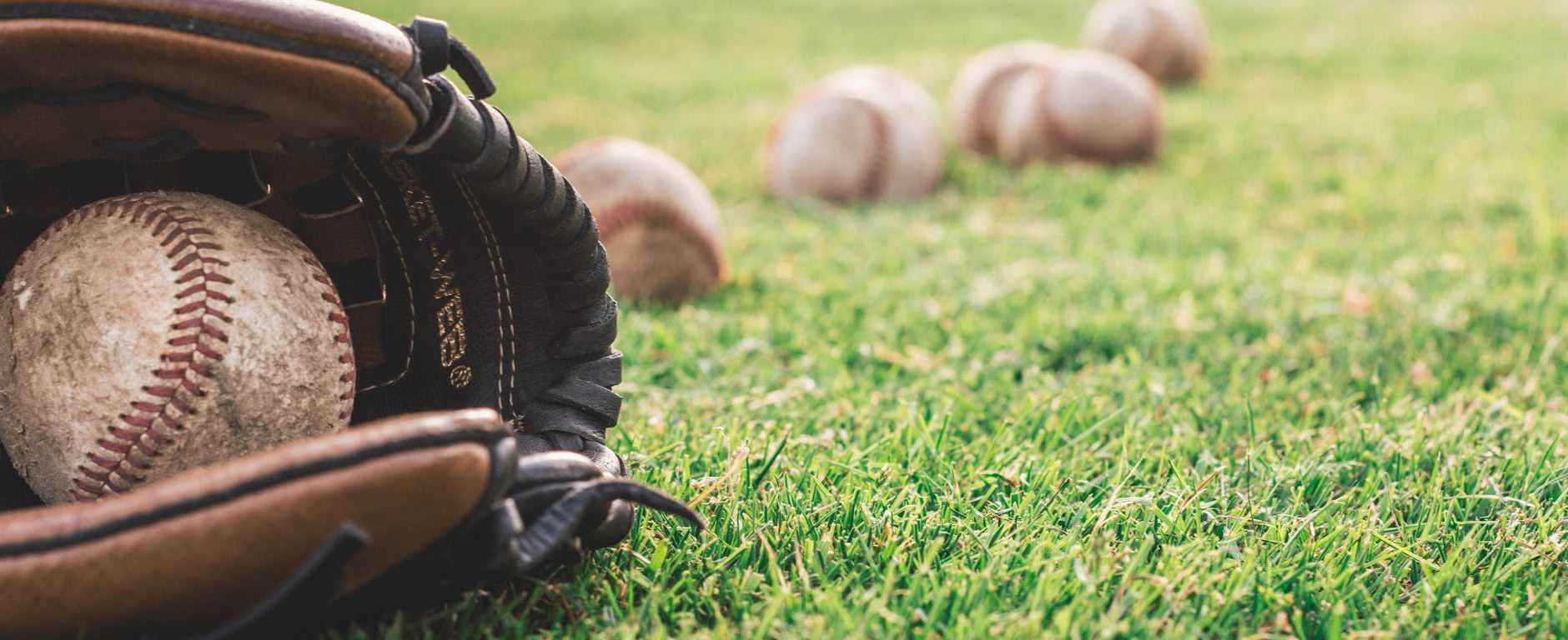 white baseball ball on brown leather baseball mitt